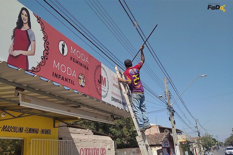 comunicacao visual juliana modas instalando letreiro agencia fado
